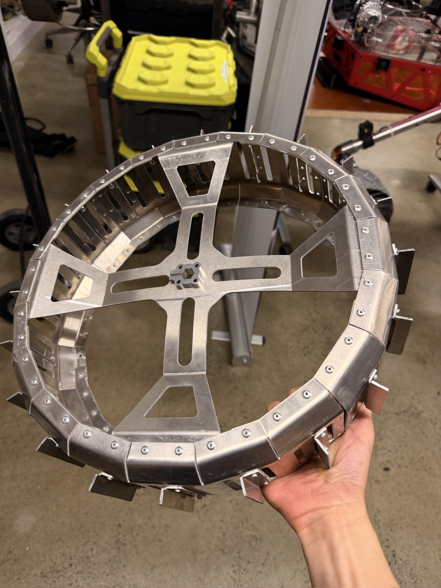 Jeremy holding a personally fabricated aluminum rover wheel assembly